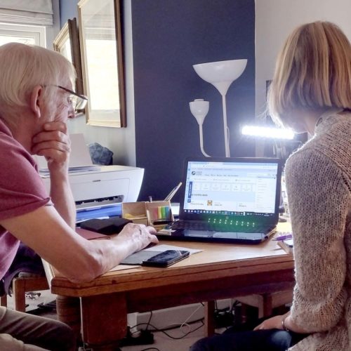 Two people looking at a laptop.