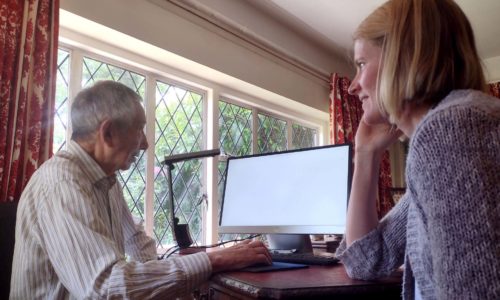 Jean, our Volunteer Coordinator with a Tech to Community Connect member looking at a computer.