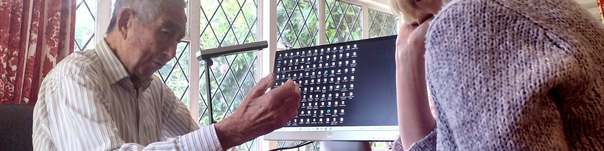 Two people looking at a computer as part of the Tech to Community Connect Project