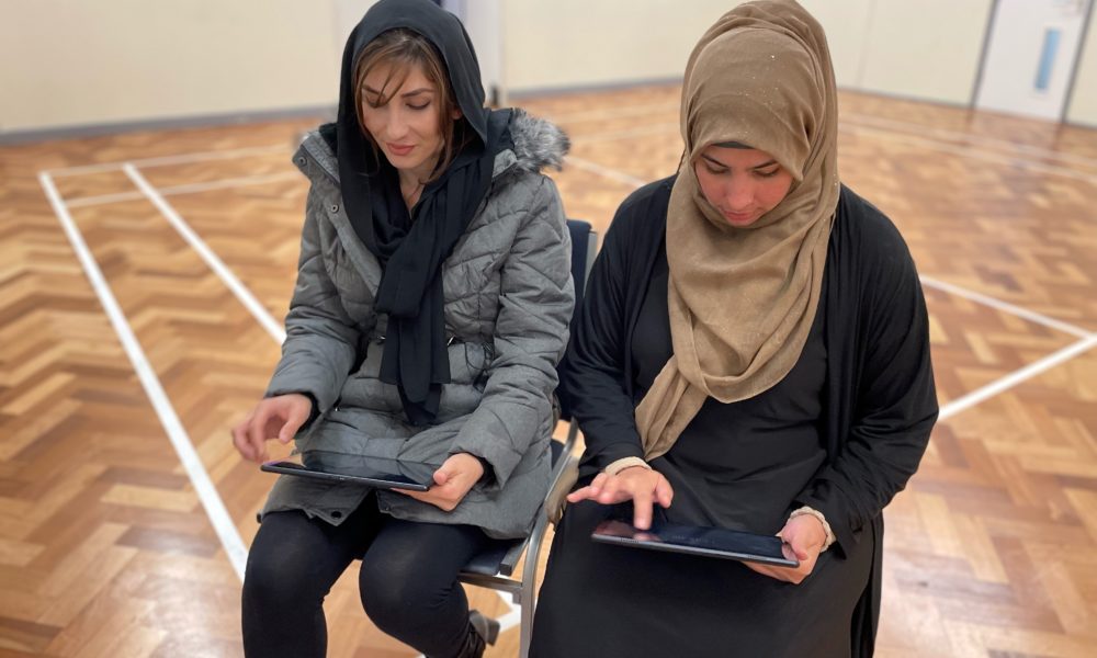 Two people looking at a tablet device