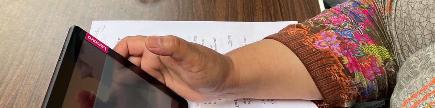 Somebody sitting at a desk holding a tablet