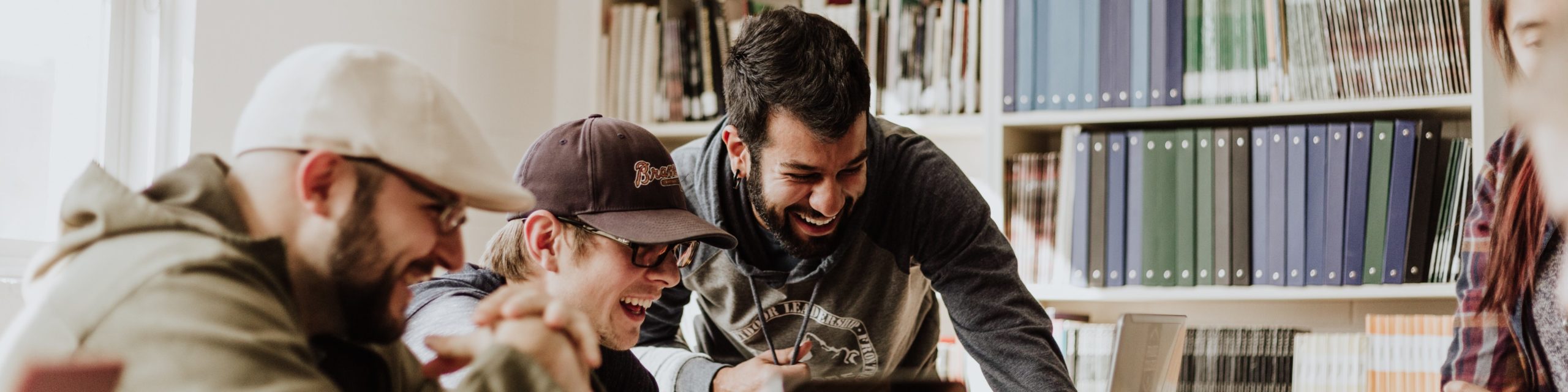 A group of people crowded around the computer smiling