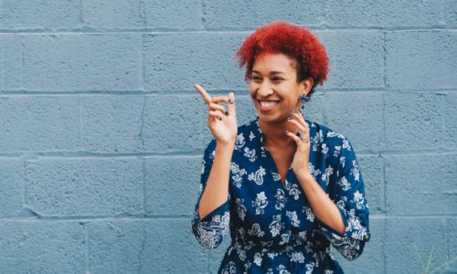 Lady smiling while pointing to her right handside