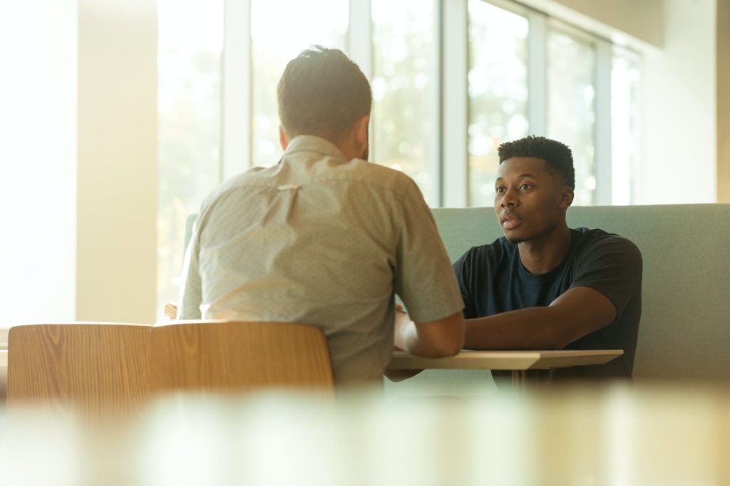 Two men sat at a table talking