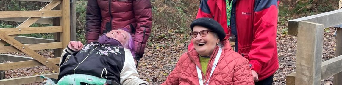 Two coalition members, who are wheelchair users, smiling and laughing