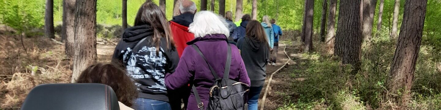 Group of Coalition staff and members walking and wheeling through a forest