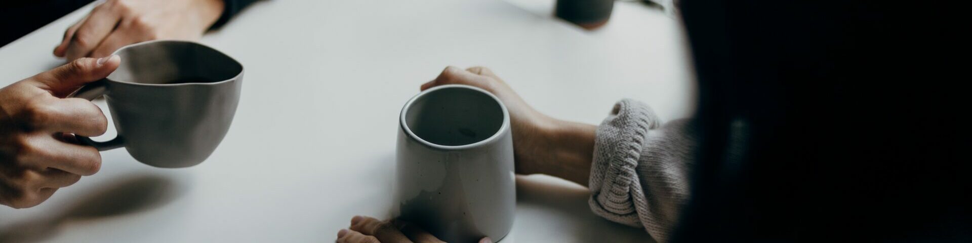 Two people at a table holding cups of tea