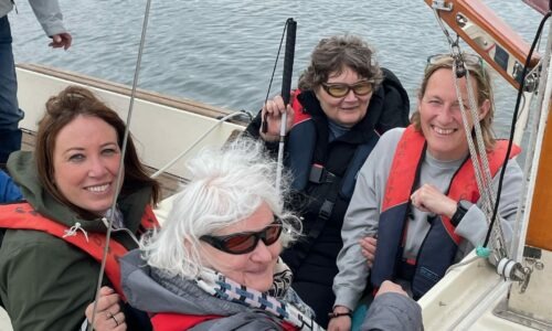 Two Coalition members and two Coalition staff members on a sailing boat at a Get More Active Get Together event