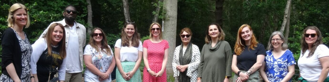 Group photo of the Coalition team on a staff away day with a forest in the background