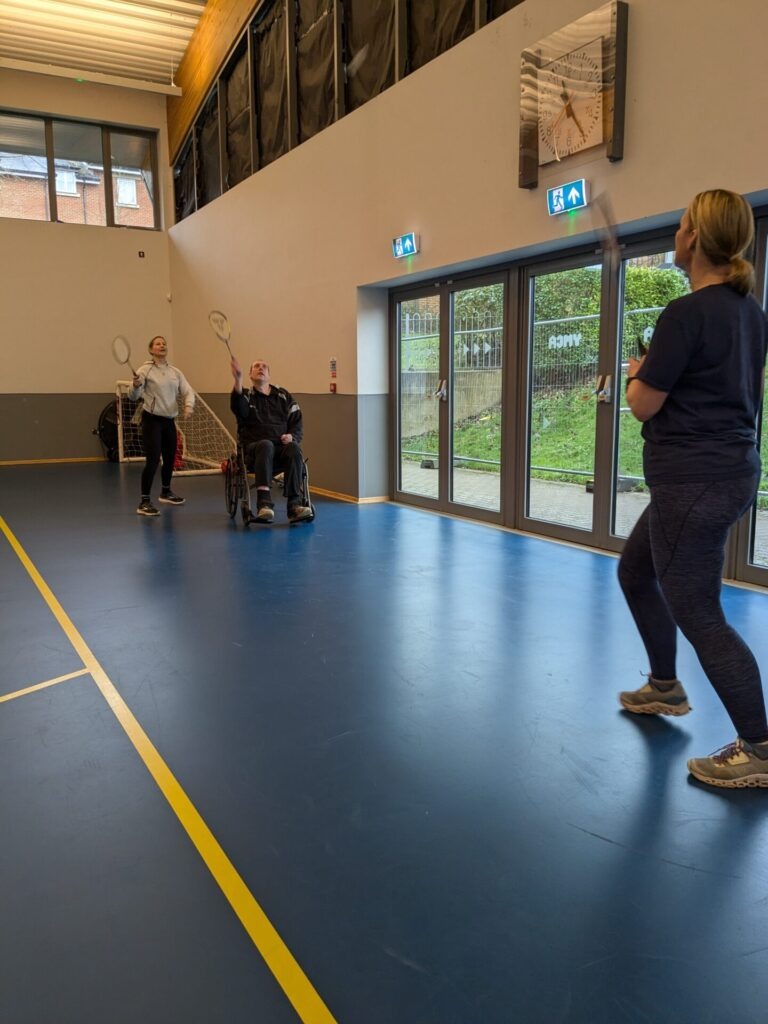 Coalition member playing badminton with Coalition staff members Katy and Rachel. 