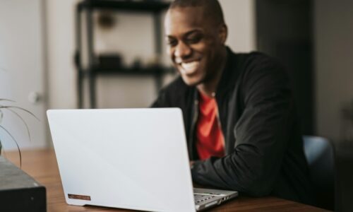 Man smiling and looking at laptop