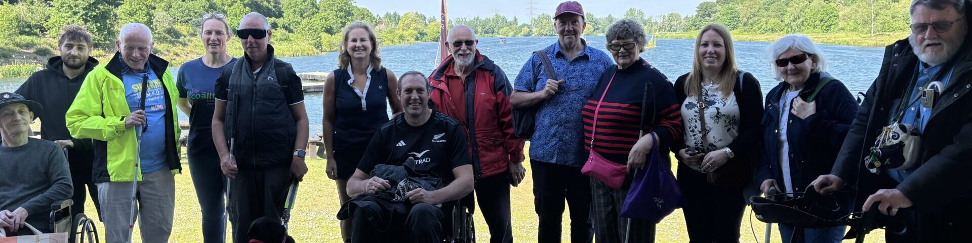Coalition members and staff in front of a lake at a sailing event.