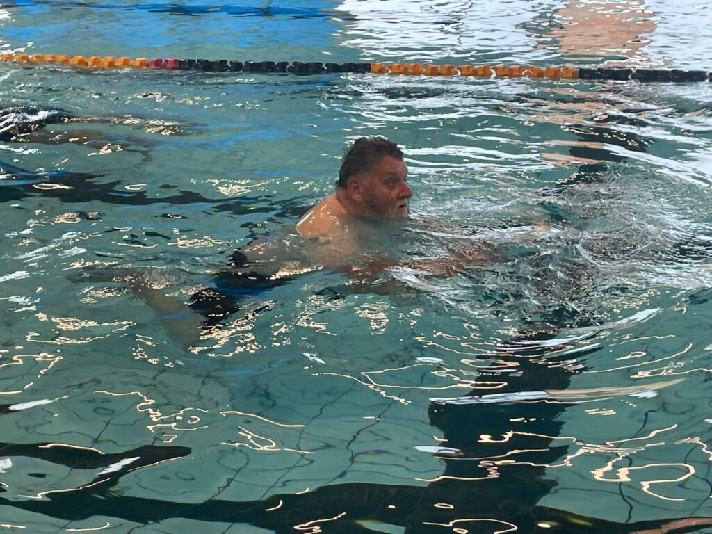 Member David swimming in a swimming pool.