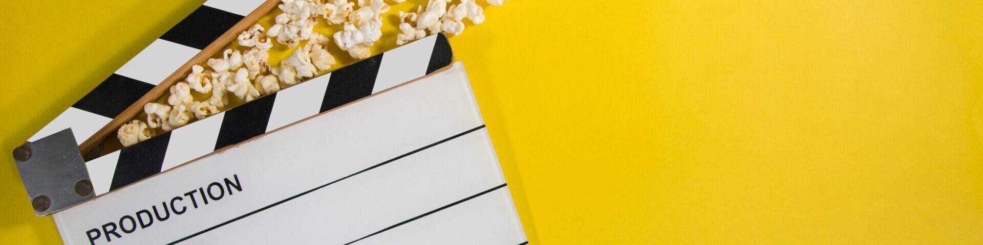 yellow background with a clapperboard and popcorn