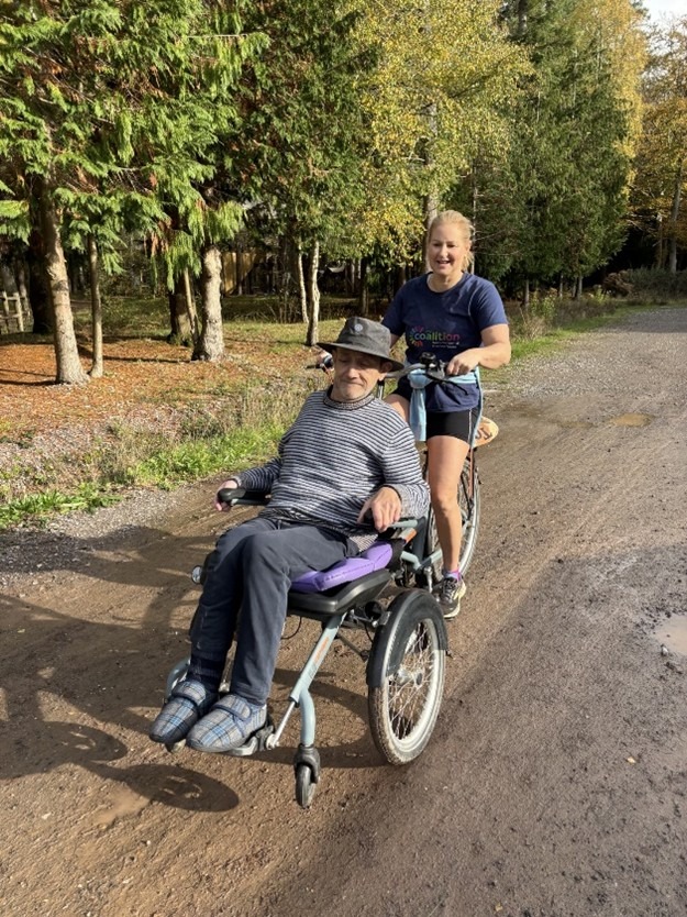Coalition member with staff member, Rachel, on a three-wheeler wheelchair bike.