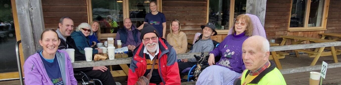 Group of Coalition members and staff smiling around a table at Alice Holt cafe.