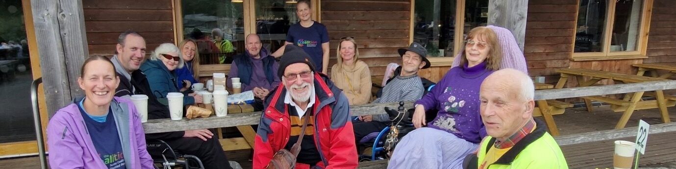 Group of Coalition members and staff smiling around a table at Alice Holt cafe.