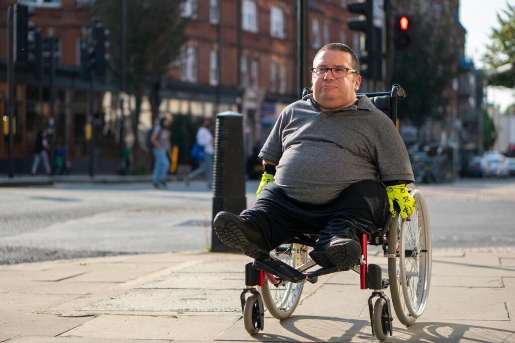 Wheelchair user wheeling along a highstreet.