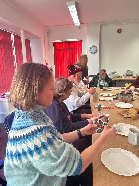 Coalition members and staff around a table creating Christmas crafts