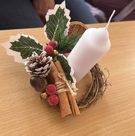 Christmas craft of a candle with holly. 