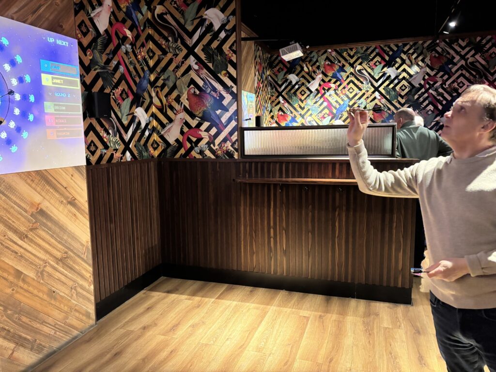 Coalition member aiming a dart at a digital darts board