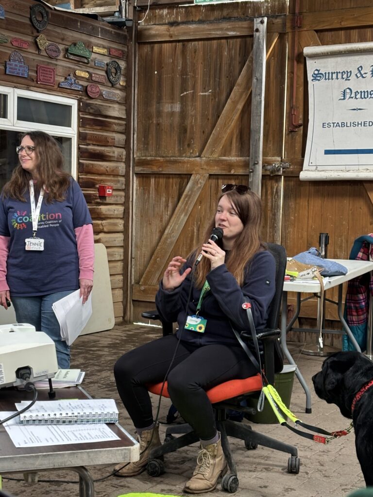 Coalition staff Jennie and Megan at the Rural Life Centre. Megan is speaking to a group and has a microphone. 
