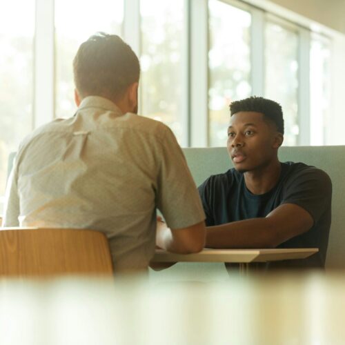 Two men talking at a table