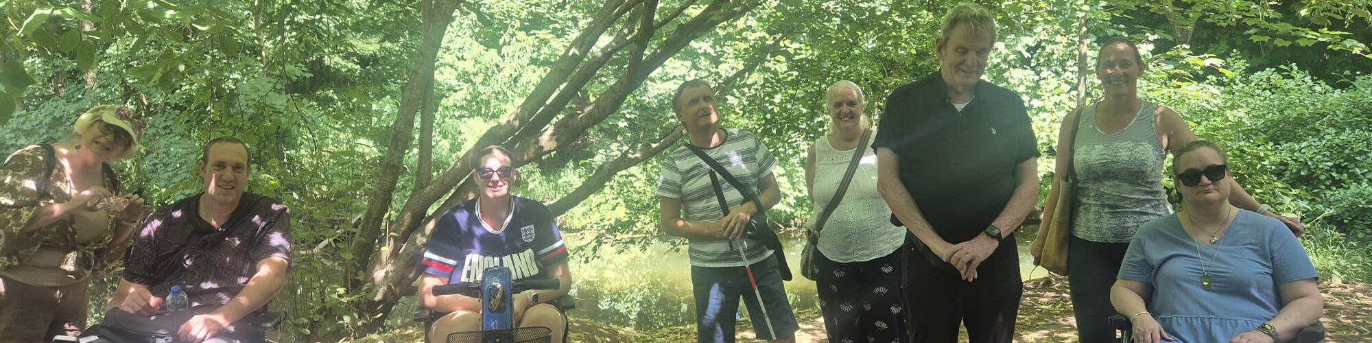 Group of Coalition members with staff member Katy, under a tree
