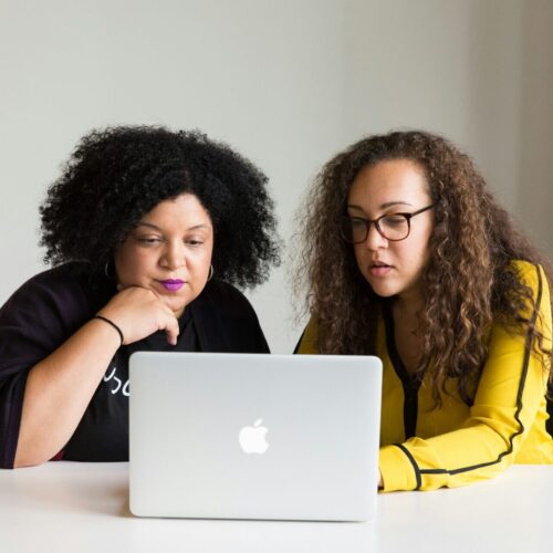 Two woman looking at a laptop.